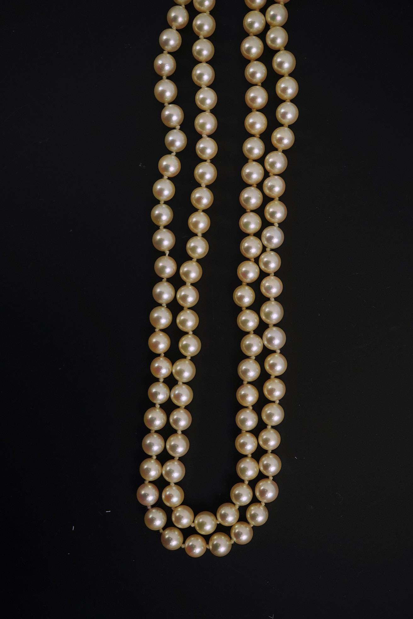 A modern double strand cultured pearl necklace, with 18k gold and diamond set twin ring clasp